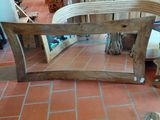 a table that is made out of wood and has a mirror on it