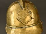 an antique brass helmet with a shield on top of it