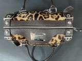 leopard print handbag hanging on a hook on a wall