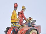 two figurines of a man and a woman riding on a motorcycle