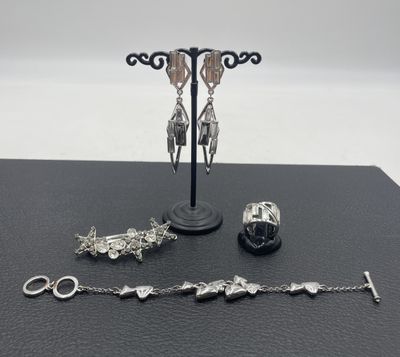 une présentation de bijoux en argent sur une table noire