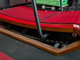 a red bench that is on the ground in the middle of a cage