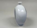 a white vase that is sitting on a table