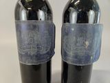 two bottles of wine with labels on them sitting next to each other