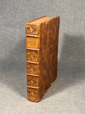an old book sitting on top of a table next to a gray background