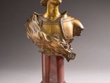 an antique bronze bust of a woman on a marble pedestal