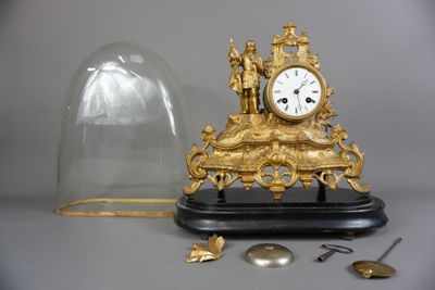 une horloge placée sous un dôme de verre sur une table