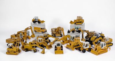 de nombreux engins de chantier miniatures posés sur une surface blanche