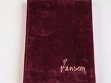 maroon velvet notebook with gold writing on it on a white surface
