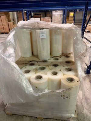 several rolls of plastic are stacked on top of a pallet in a warehouse