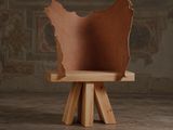 une chaise en bois avec une assise en cuir marron, posée sur un piètement en bois