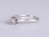 a close up of a diamond ring on a white surface