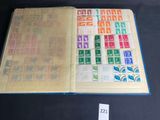 an open book with stamps on it on a table