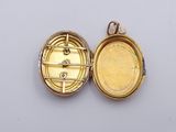 a small gold locke with a key inside of it