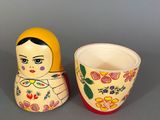 a small cup and a small doll on a table