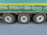 a green semi truck with a yellow stripe on the side of it