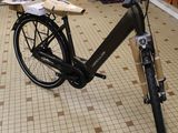 a bike that is parked in a store with a clock on the wall