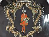 a decorative plate with a picture of a woman in an orange dress