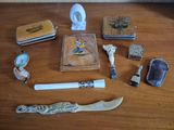 une table en bois sur laquelle se trouvent divers objets, notamment un couteau, un briquet, un briquet et d'autres objets