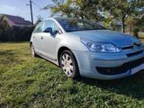 a silver car is parked in the grass in front of a house