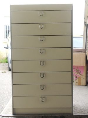 a white cabinet with five drawers on top of it