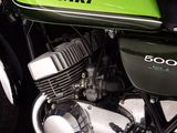 a green motorcycle parked in front of a black wall