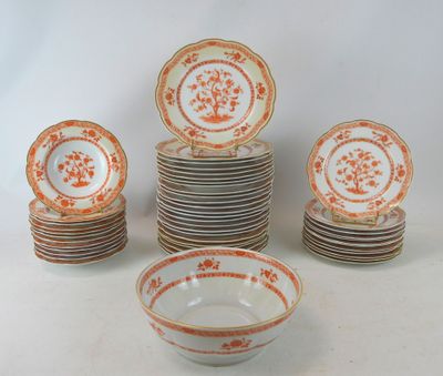 many plates and bowls with orange designs on them