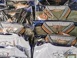 many bags of shirts that are on display in a store