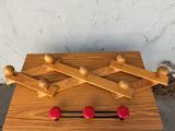 une planche en bois sur laquelle se trouvent des boules et des chevilles en bois