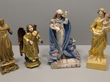 quatre figurines représentant Jésus, Marie et d'autres personnages religieux, posées sur une table