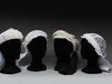 trois têtes de mannequins noires coiffées de chapeaux blancs
