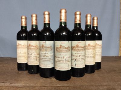 six bottles of wine are lined up on a wooden table