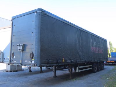 un gros semi-remorque avec une bâche à l'arrière