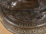 a bronze statue of a woman holding a dog