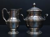 two silver vases sitting next to each other on a table