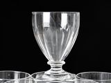 four glasses sitting on a table with a glass goblet