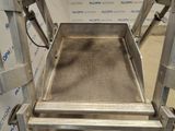 stainless steel conveyor belt on a conveyor belt in front of a wall