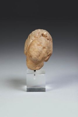a close up of a small head of a person on a stand