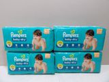 four boxes of pampers baby dry diapers sitting on a table