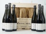 trois bouteilles de vin sont posées devant une caisse en bois