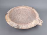 a small bowl with a handle on a gray surface