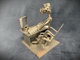 a sculpture of a man sitting at a desk with a computer on it