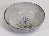 a white bowl with a blue flower on it