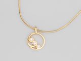 un collier plaqué or avec un pendentif circulaire et deux petites pierres blanches