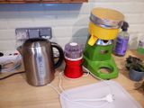 a green and yellow blender sitting on a counter next to a cutting board