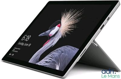 the surface book is open on a white surface with a bird on it