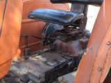 a dog sitting on the seat of an old tractor