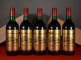 four bottles of wine are lined up on a red table