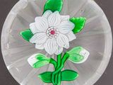 a glass plate with a flower on it on a table