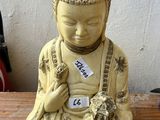 une petite statue représentant une personne assise sur une table